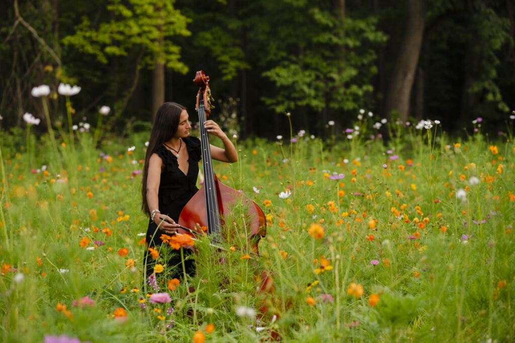 Magical high school senior portrait of girl and her cello in a field of wildflowers.