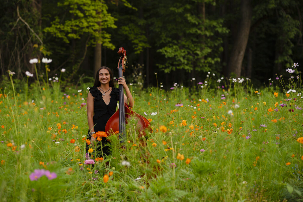High school senior smiling with her cello.