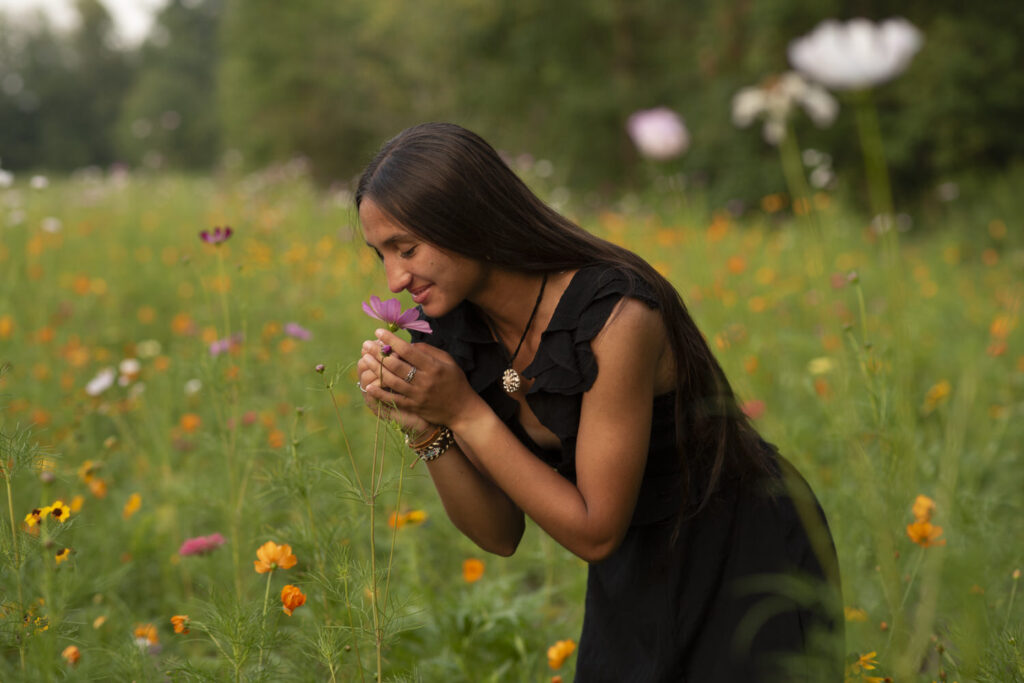 Dreamy portrait of high school senior smelling wildflowers taken by Henwood Studios.