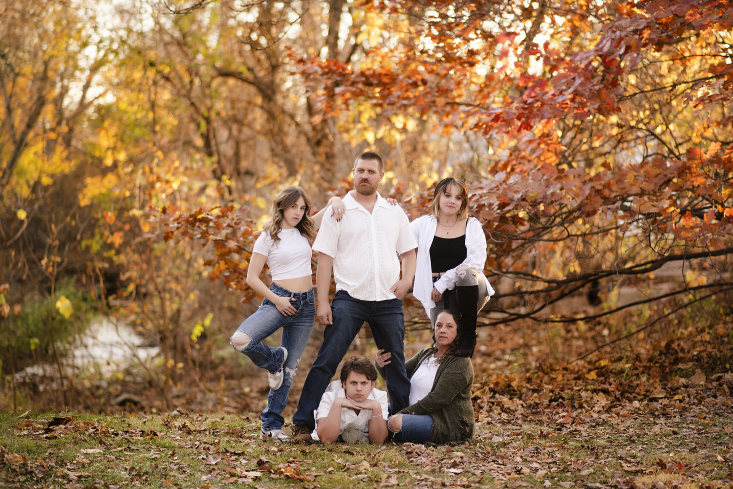 Fun and goofy family photo taken in front of fall foliage by Henwood Studios.